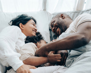 Image of couple laying in bed with child in the middle